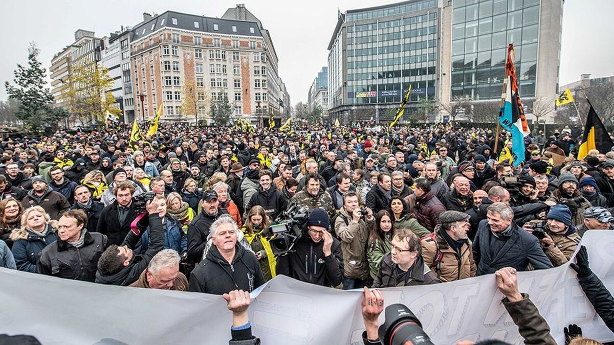 People wave the flag of the Flanders as they take part in a gathering called by the right-wing Flemish party Vlaams Belang and other organisations, in Brussels, on December 16, 2018 to protest against the UN Marrakech global pact on migration signed last week by Belgian Prime Minister. - Brussels mayor forbade the venue of this march but State council ruled against that decision and the mach is wel authorized. A counter march is also organised for a solidary Belgium. (Photo by JONAS ROOSENS / BELGA / AFP) / Belgium OUT