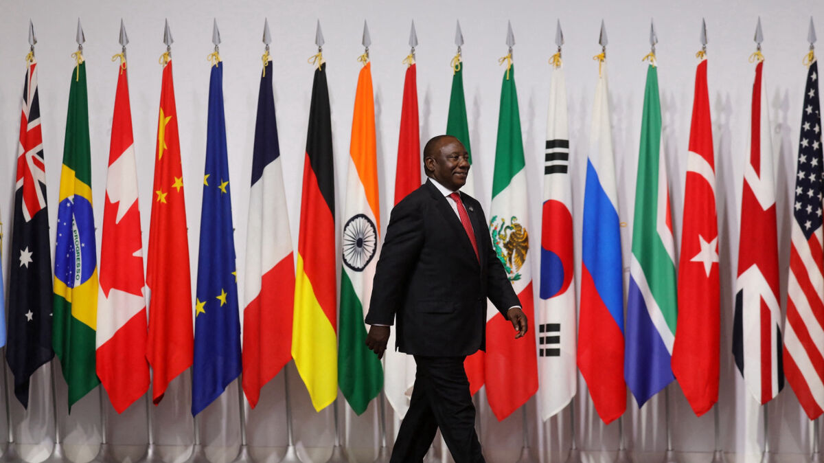 South Africa's President Cyril Ramaphosa walks past G20 member flags as he is welcomed by Japan's Prime Minister Shinzo Abe to the G20 Summit in Osaka on June 28, 2019. (Photo by Ludovic MARIN / POOL / AFP)