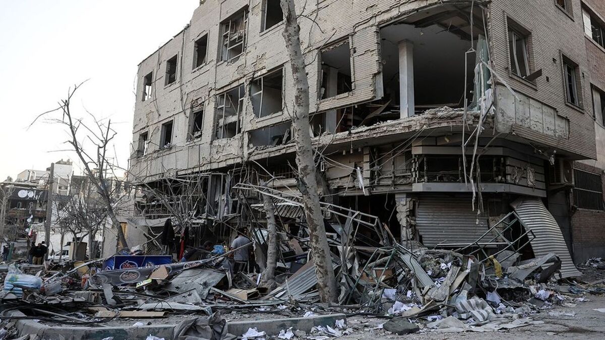 Residents stand amid debris beside a damaged residential building near Niloufar square in Tehran during the ongoing joint US-Israeli military campaign on Iran on March 2, 2026. The United States and Israel launched strikes against Iran on February 28, killing Iran's supreme leader and top military leaders, prompting authorities to retaliate with strikes on Israel and across the Gulf. (Photo by AFP)
